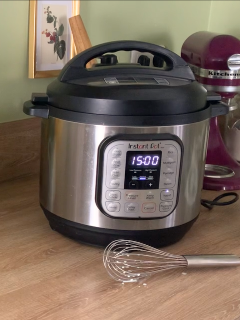 Instant pot with the yogurt function turned on. Whisk in foreground
