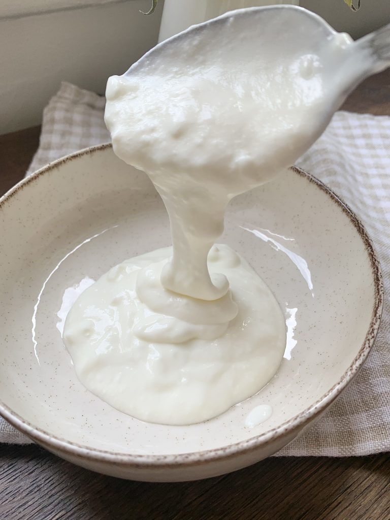 Spooning homemade yoghurt three ways into a bowl