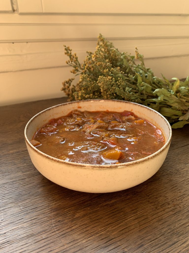 Autumn Pork Goulash Stew Recipe with dried flowers in the background