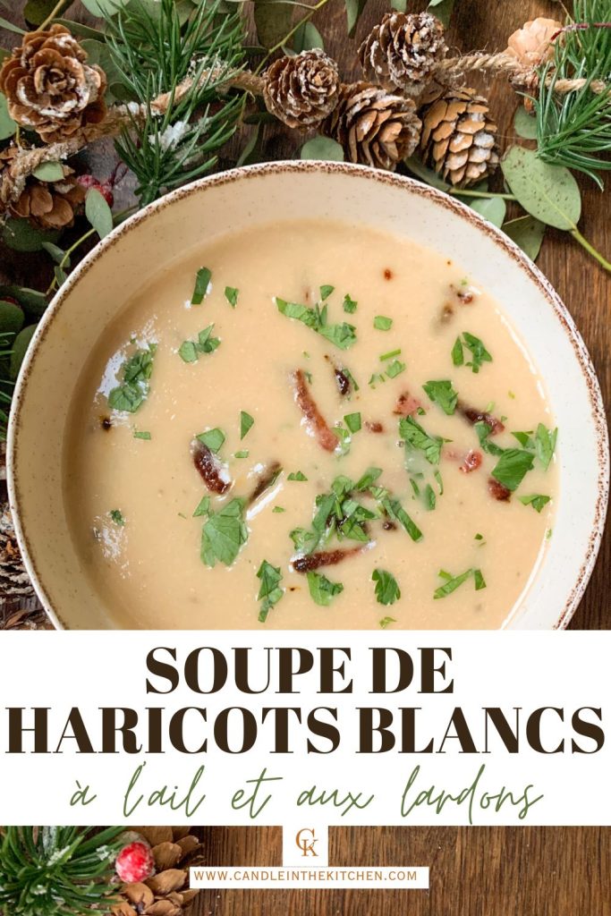 Creamy white bean soup with roasted garlic and bacon on a wooden table with christmas garland