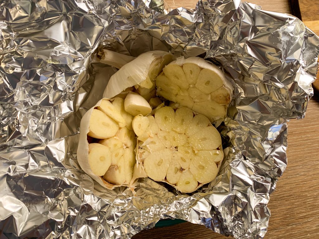2 heads of garlic halved in aluminium foil drizzled with olive oil ready to be roasted