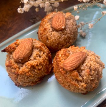 3 sugar free cookies with almond flour, honey and cinnamon on a blue plate with dried flowers