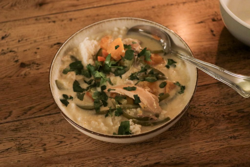 Coconut chicken soup in a small bowl with a spoon