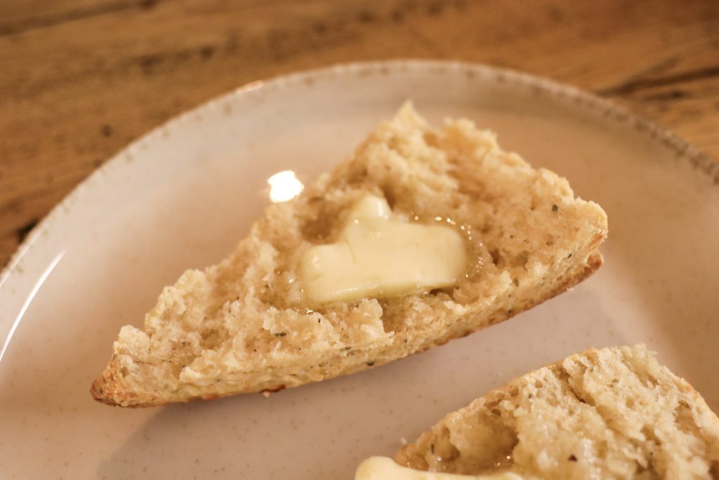 Close up of sourdough cheese scone with butter melting