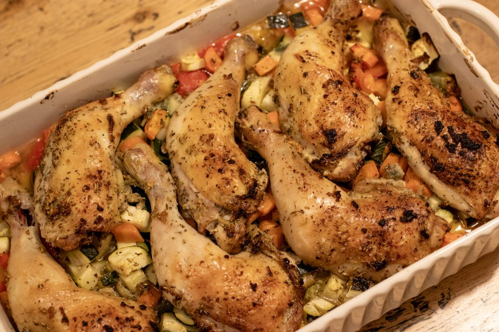 Sheet Pan Lemon and Garlic Chicken with Veggies in a white ceramic dish