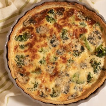 Broccoli and Blue Cheese quiche seen from above with green striped tea towel