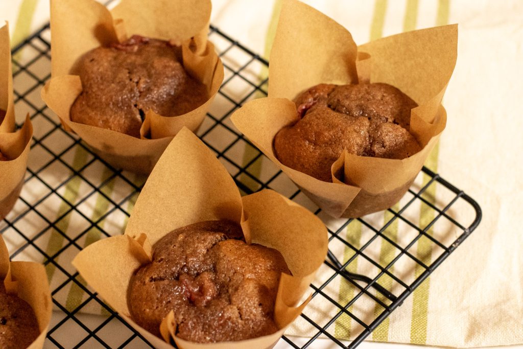 Dairy Free Sourdough Strawberry muffins in brown tulip cases on a black wire rack
